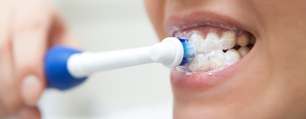 woman brushing her teeth close up