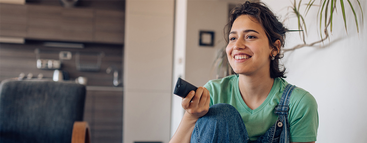 woman pointing remote at tv